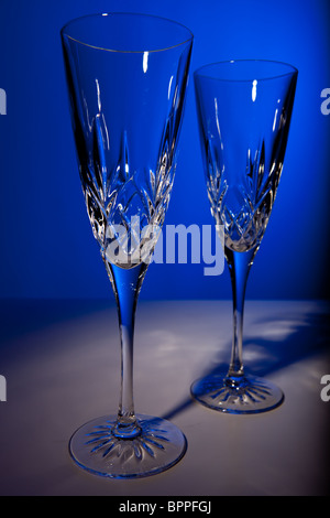 Studio shot di due crystal champagne flauti contro uno sfondo blu Foto Stock