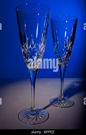 Studio shot di due crystal champagne flauti contro uno sfondo blu Foto Stock