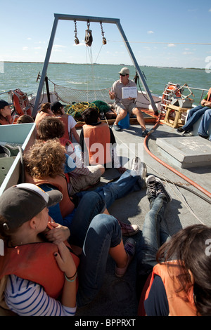 Gli studenti delle scuole medie ascoltano il biologo marino durante una gita sul campo a bordo di una nave di ricerca nel Golfo del Messico, appena fuori Corpus Christi, Texas Foto Stock