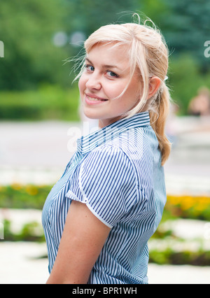 Outdoor ritratto di donna sorridente alla fotocamera. Foto Stock