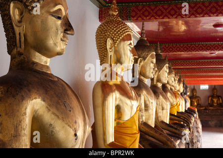 Fila di statue di Buddha, Wat Pho, xvii secolo tempio di Bangkok, Tailandia Foto Stock