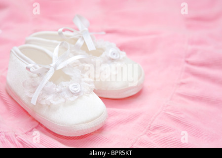 Belle scarpe per bambini su una rosa abito bambino. Foto Stock