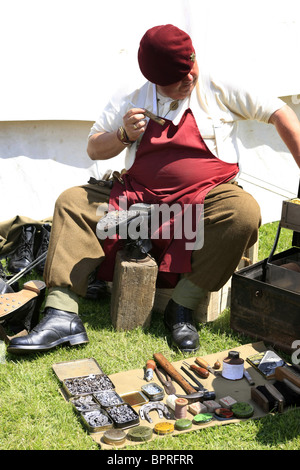 WW2 Rievocazione Storica i membri dal reggimento paracadutisti mend stivali e attrezzatura di compagni soldati durante un insieme Foto Stock