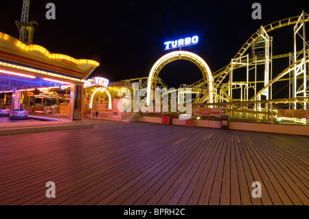 Luna park giostre illuminate di notte sul molo di Brighton East Sussex England Foto Stock