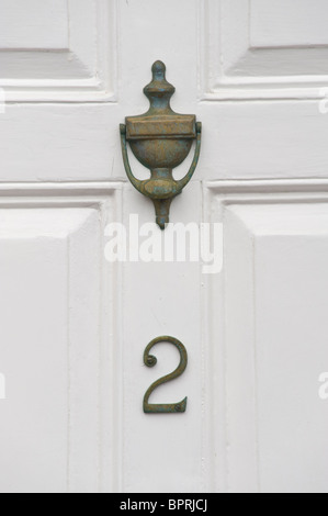 Numero 2 in legno dipinto di bianco con pannelli porta anteriori con ottone respingente di casa nel Regno Unito Foto Stock