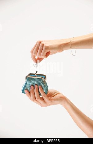 Donna assume trimestre dal suo blue portamonete Foto Stock