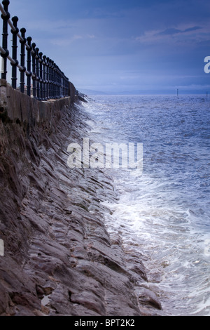 Il mare e le onde contro una parete del mare sulla costa nel Wirral, Inghilterra Foto Stock
