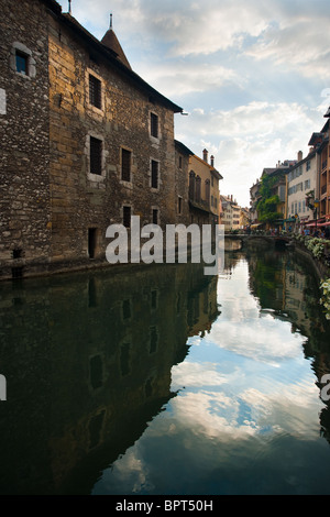 La vecchia prigione di Annecy, Palais de l'isle, che si riflette in un canale. Foto Stock