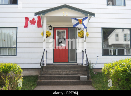 Le bandiere della Nova Scotia e Canada sono visto volare al di fuori della casa di un canadese patriottica in Lunenburg, Nova Scotia, Canada. Foto Stock