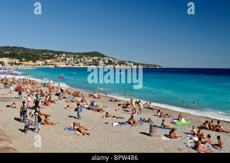 Una folla di persone a prendere il sole sulla spiaggia a Nizza Foto Stock