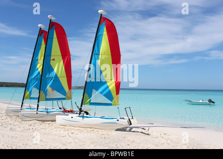 Colorate barche a vela in affitto su una spiaggia tropicale a Half Moon Cay nelle Bahamas Foto Stock