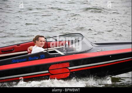 Giovane uomo che cavalca una barca veloce durante la vela 2010 sfilata di barche sul fiume Ij, Amsterdam, Paesi Bassi Foto Stock