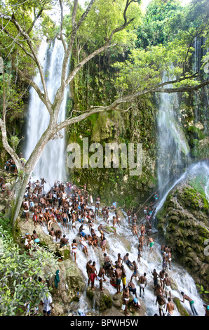 Una folla di operatori Voodoo culto al di sotto di una cascata durante il Saut D'eau festival Voodoo in Haiti. Foto Stock
