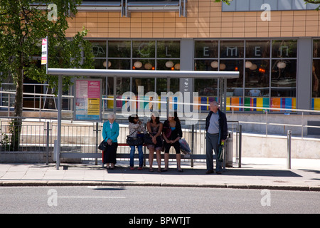 In Irlanda del Nord, Belfast, Università Road, la gente seduta alla fermata in attesa di bus. Foto Stock