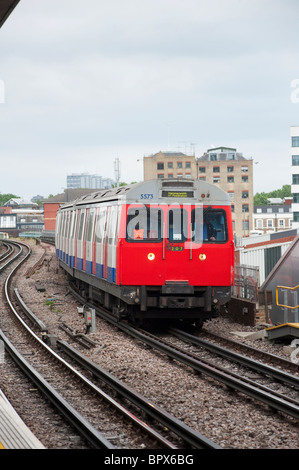 Treno in avvicinamento a una stazione della metropolitana di Londra, Inghilterra. Foto Stock