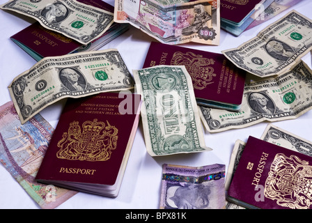 Regno Unito passaporti posa su varie banconote provenienti da tutto il mondo, compresi i dollari americani, dollari canadesi. Foto Stock