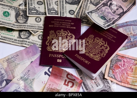 Regno Unito passaporti posa su varie banconote provenienti da tutto il mondo, compresi i dollari americani, dollari canadesi Foto Stock