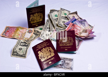 Regno Unito passaporti posa su varie banconote provenienti da tutto il mondo, compresi i dollari americani, dollari canadesi. Foto Stock