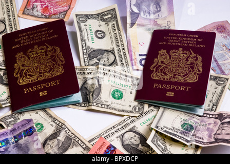 Regno Unito passaporti posa su varie banconote provenienti da tutto il mondo, compresi i dollari americani, dollari canadesi. Foto Stock