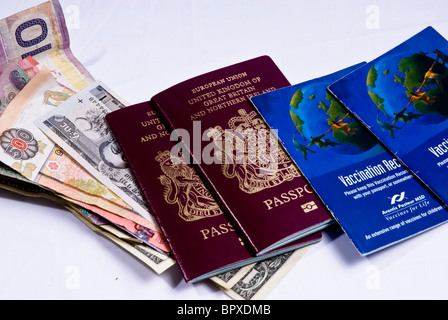 Regno Unito i passaporti e i libri di vaccinazione posa su varie banconote provenienti da tutto il mondo, compresi i dollari americani. Foto Stock