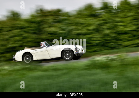 Austin Healey 3000MKIII 1965 guida su un paese di lingua inglese road a velocità Foto Stock