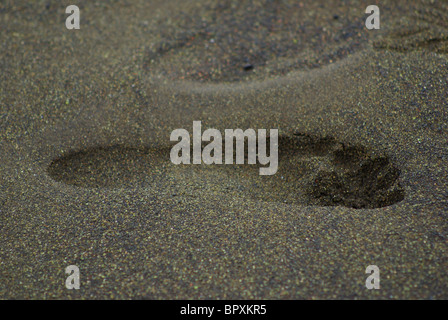 Una profonda impronta umana in verde olivite sabbia su una spiaggia alle Hawaii Foto Stock