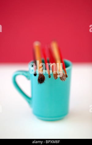 Artisti tazza da caffè con pennelli Foto Stock