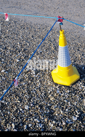 Traffico di colore giallo con cono blu corde di nylon che indica assenza di accesso o di parcheggio su area della superficie di ghiaia Foto Stock