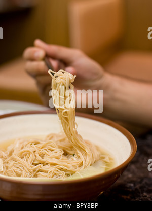 Gamberetti zuppa wonton mangiata con il cucchiaio e bacchette al ristorante cinese Foto Stock