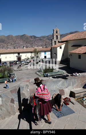 Vista su Plaza San Blas Square e la chiesa, la donna Quechua locale che ha allestito una bancarella in primo piano, Cusco, Perù Foto Stock