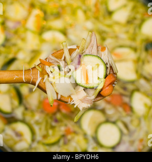 Cucchiaio di legno in una pentola di fatti in casa zuppa di pollo Foto Stock