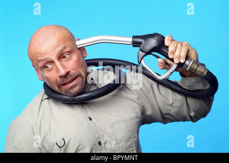 Uomo con un ugello di benzina contro la sua testa Foto Stock