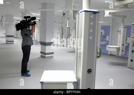 Un cameraman TV film all'interno di un nuovo ospedale per TV news. Foto Stock
