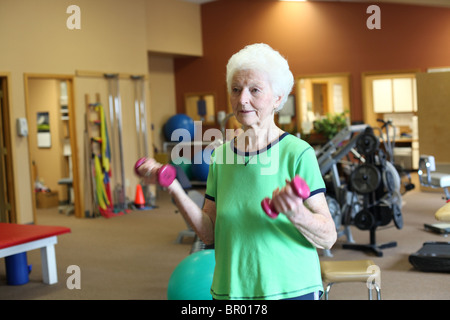 Sana donna senior di esercizio con pesi in palestra Foto Stock