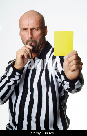 Un arbitro di calcio che mostra un cartellino giallo Foto Stock