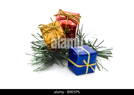 Tre piccole scatole regalo sul ramo di pino Foto Stock