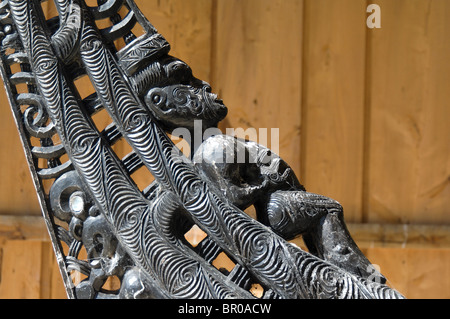 Nuova Zelanda, Isola del Sud, Oakins Bay. Sculture in legno su un tradizionale Maori canoa. Foto Stock