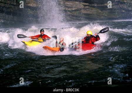 Un padre e i suoi due figli kayak insieme in un fiume. Foto Stock