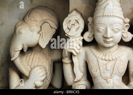 Bianco antiche sculture in pietra di Ganesha e Krishna decorare un tempio indù di Udaipur, Rajasthan, India. Foto Stock