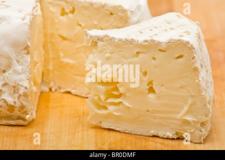 Fette di deliziosa crema di formaggio sul tagliere di legno Foto Stock