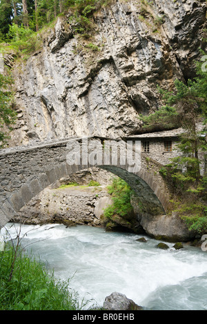 Un antico ponte in pietra e home su Dora Verney in Pre Saint Didier, Valle d'Aosta, Italia Foto Stock