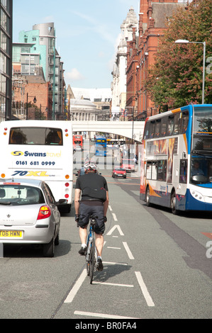Ciclista viaggia lungo Oxford Road,Manchester. Foto Stock