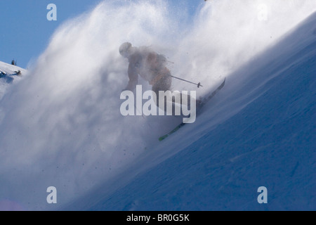 Un uomo sci polvere di neve in una giornata ventosa sul vertice Donner in California. Foto Stock