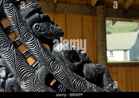 Nuova Zelanda, Isola del Sud, Oakins Bay. Sculture in legno su un tradizionale Maori canoa. Foto Stock