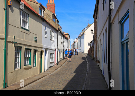 Turisti e Agriturismi ciottoli Henrietta Street, Whitby, North Yorkshire, Inghilterra, Regno Unito. Foto Stock