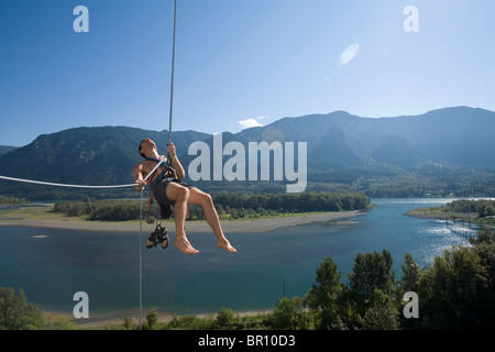 Giovane donna belays rocciatore alta sopra la Columbia River. Foto Stock