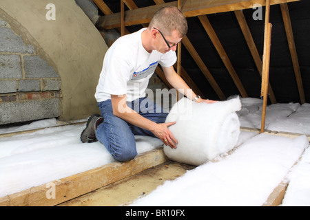 Uomo di posa isolamento loft in soffitta roofspace Foto Stock