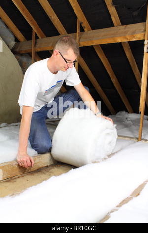 Uomo di posa isolamento loft in soffitta roofspace Foto Stock