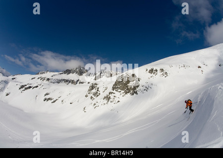 Uomo di telemark sci giù per la collina in Canada backcountry vicino Alaska i confini del Canada. Foto Stock