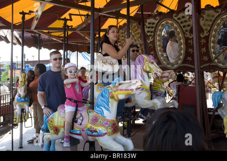 La giostra è un preferito ride per i genitori e i figli piccoli simili a Coney Island, Brooklyn, New York. Foto Stock